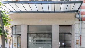 Ein Gebäude mit einem modernen Eingang, der eine Glastür und ein Metallvordach besitzt.