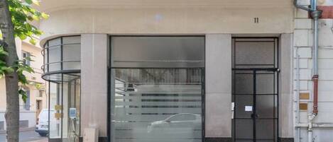 A building with a modern entrance featuring a glass door and a metal canopy.
