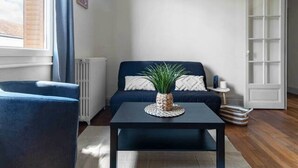 Ein modernes Wohnzimmer mit Sofa, Couchtisch und einer Pendelleuchte.