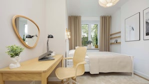 A bedroom with a bed, a desk with a laptop, a chair, a bedside table, a mirror, and a window with curtains. - Bright Apartment | Place to Work | Close to the Royal Baths (Warszawa)