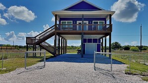 A two-story building with a balcony and a covered walkway. - Fish Tales by Miss Kitty’s (Rockport)