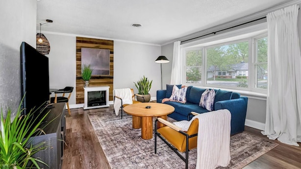 Ein modernes Wohnzimmer mit blauem Sofa, Couchtisch aus Holz und Kamin.