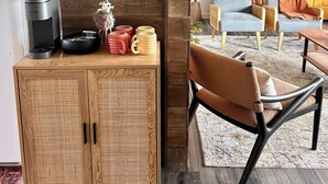 A living room with a wooden cabinet, a framed picture, and a chair.