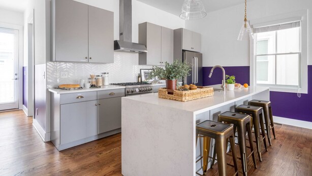 A modern kitchen with a large island, grey cabinets, stainless steel appliances, and a purple accent wall. - Sleeps 24 2 Homes, Minutes to Downtown+broadway Faith & Barbara by Avantstay (Nashville)