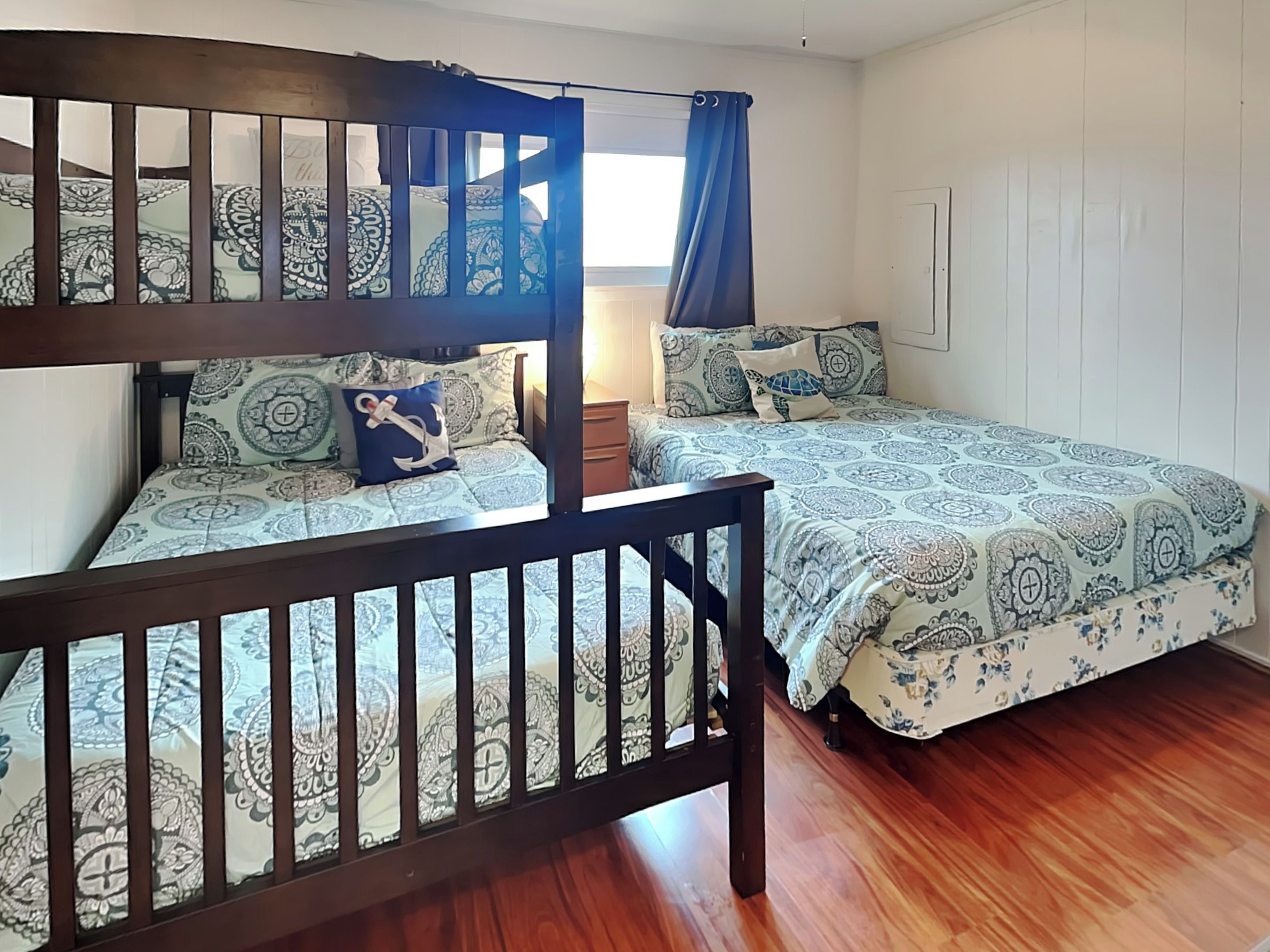A room with two beds, each with patterned bedding and a wooden headboard.