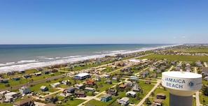 A residential area with a water tower labeled "Jamaica Beach" and a view of the ocean. - John Silver Cottage by Ryson Vacation Rentals (Galveston)