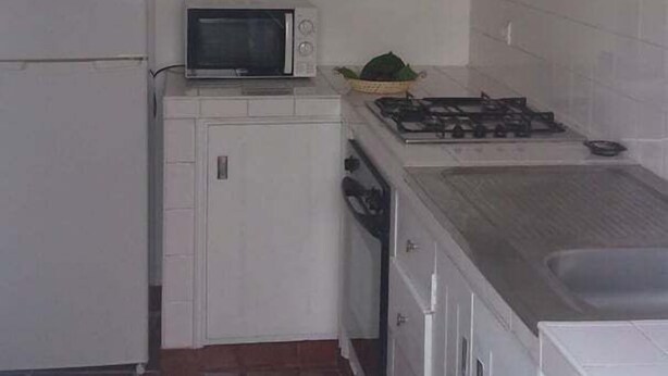 A compact kitchen with a refrigerator, microwave, stove, and oven. - GuestReady - Azores City Loft (Ponta Delgada)