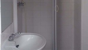 A bathroom with a white sink, a mirror, and a shower enclosure. - GuestReady - Azores City Loft (Ponta Delgada)