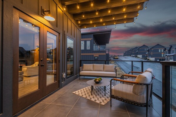 A balcony with a sofa, a small table, and a chair. - Indoor Pool | Rooftop Lounge | Theater | Sleeps 22 | Free Waterpark (Sevierville)