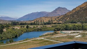 A river flowing through a valley with mountains in the background.