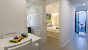 A modern hotel room with a bed, a small table with a breakfast tray, and a bathroom visible through an open door. - GuestReady - GuestHouse Passal - S. Miguel (Ponta Delgada)