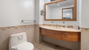 A modern bathroom with a white toilet, a wooden vanity with two sinks, and a large mirror. - Oceanfront Old San Juan Panoramic Balcony (San Juan)
