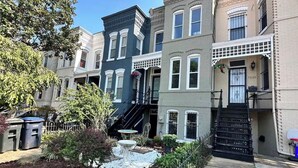 A row of townhouses with a small garden area in the foreground.