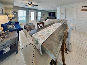 A modern living room with a sofa, coffee table, and dining table with chairs.