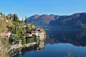 A lakeside property with multiple buildings, a dock, and a mountainous backdrop. - Balcone Di Alex & Thomas, Val Rezzo, Italy (Val Rezzo)