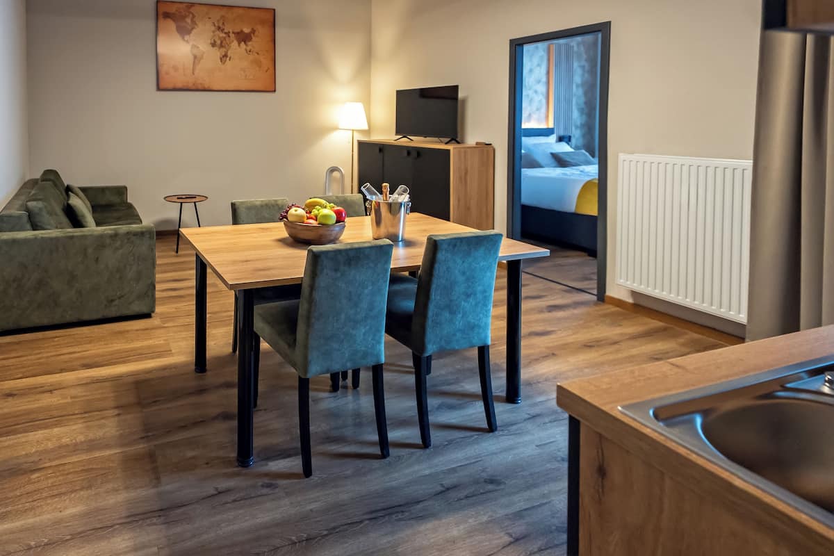 Une chambre d’hôtel moderne comprenant un coin repas, un canapé, une télévision et un lit.