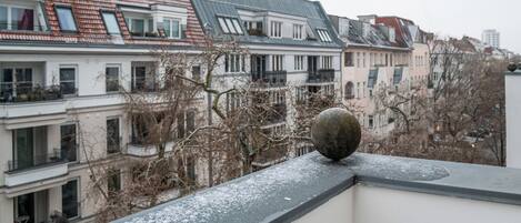Una hilera de edificios residenciales con tejados inclinados, balcones y un alero cubierto de nieve.