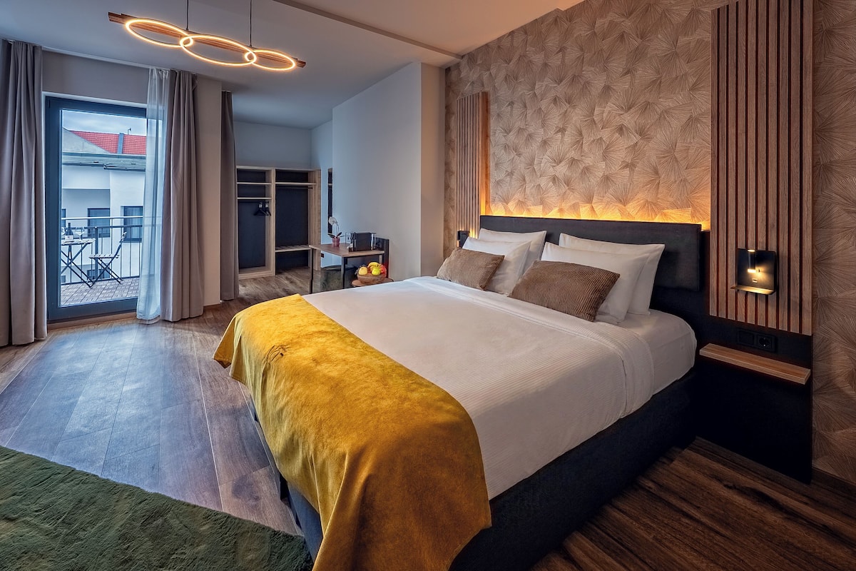 Une chambre d’hôtel moderne dotée d’un grand lit, d’un balcon et d’un mur décoratif en bois.