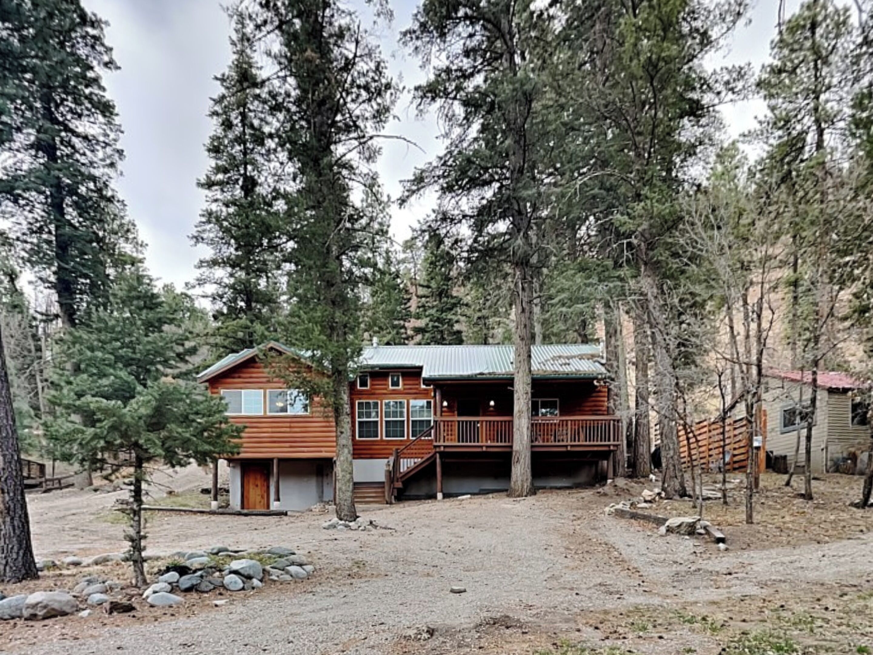 Une cabane avec une façade en bois, une véranda et un escalier menant à une terrasse.