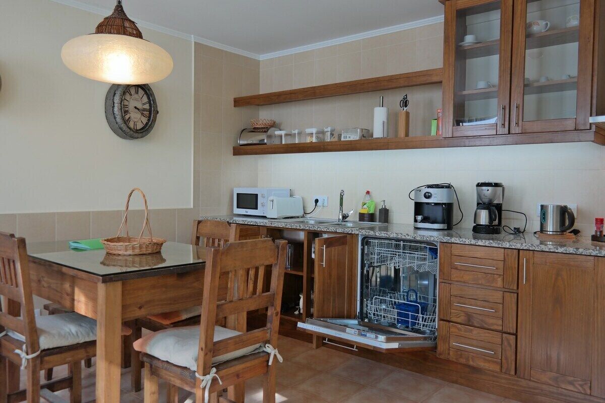 A kitchen with wooden cabinets, a microwave, a coffee maker, and a dishwasher.