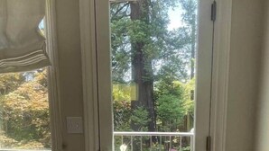 Une porte donnant sur un jardin et un arbre à l’extérieur.