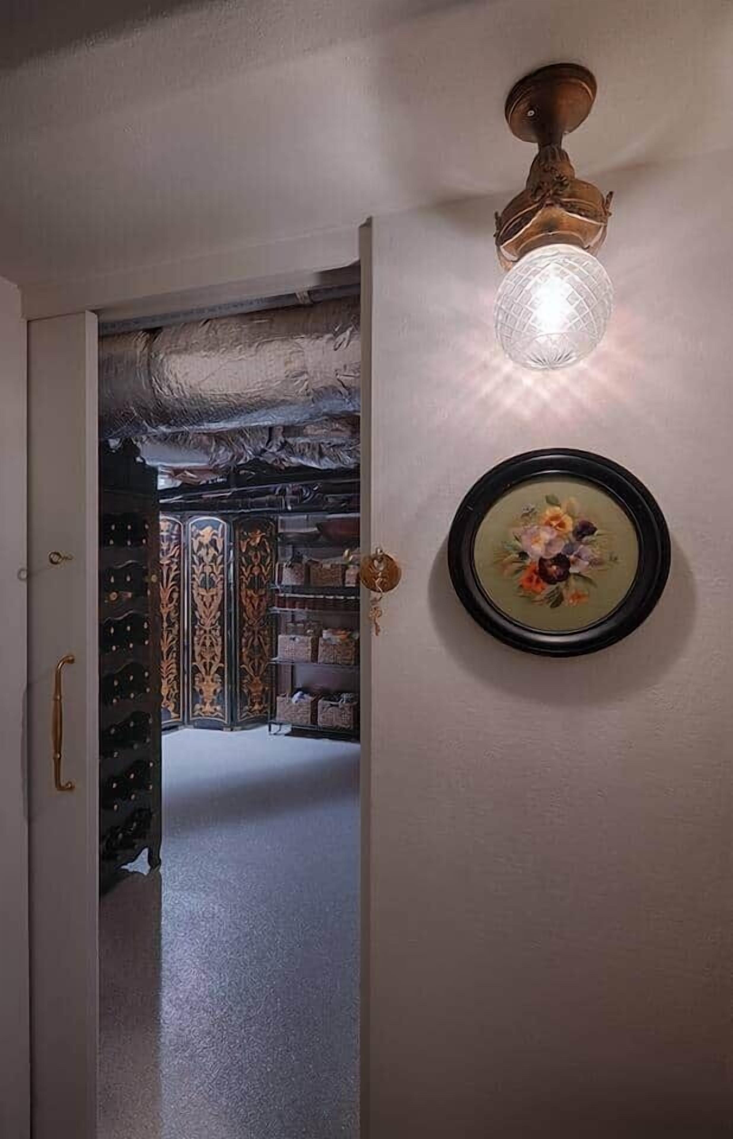 A hallway with a decorative ceiling light fixture and a framed floral artwork on the wall.