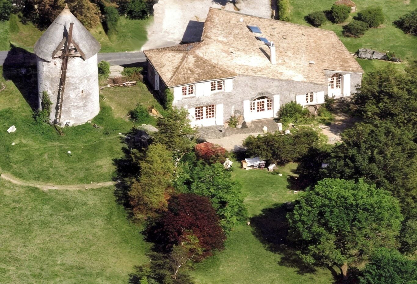 Een groot landgoed met een hoofdhuis, een toren en uitgestrekte tuinen.