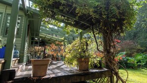 A wooden deck with potted plants and a pergola structure. - Picturesque and Comfy Escape with Waterfall View (Garden Bay)
