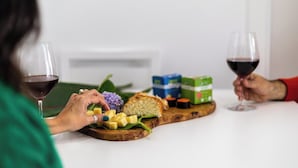 Ein Esstisch mit einer Mahlzeit aus Käse, Brot und einem Getränk.