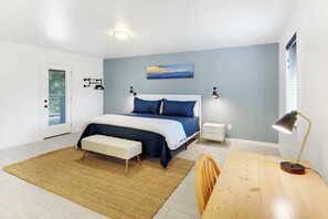 Ein modernes Schlafzimmer mit Bett, Nachttischen, Schreibtisch und Stuhl.