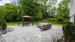 A patio with a gazebo, outdoor furniture, and potted plants. - Luxurious, fully renovated 5 bedroom home great indoor & outdoor living spaces (Newton)