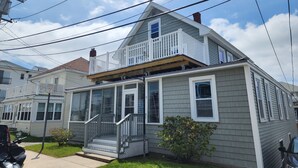 Une maison à deux étages avec un porche à l’avant, un balcon et un garage.