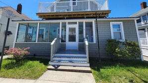 Une maison à deux étages avec un balcon, une véranda et un garage.