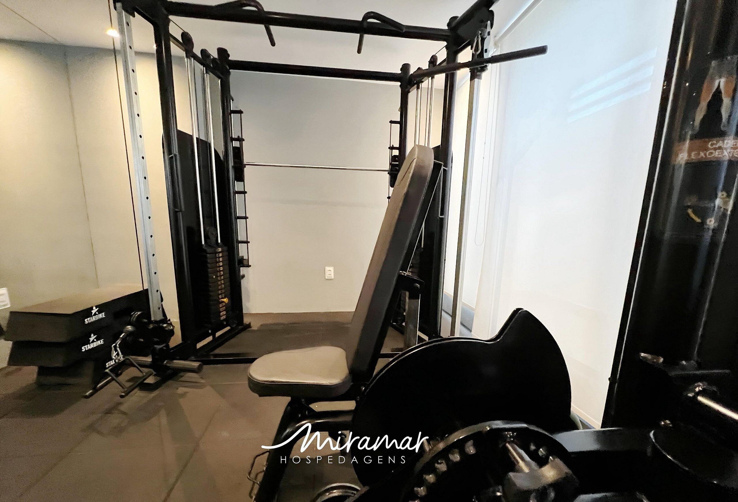 A gym with a pull-up bar, weight bench, and various exercise machines.