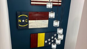 Een trap met een donkerblauwe muur, houten treden en witte leuningen.