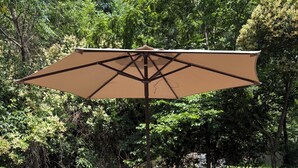 Een houten terras met een picknicktafel en een parasol.