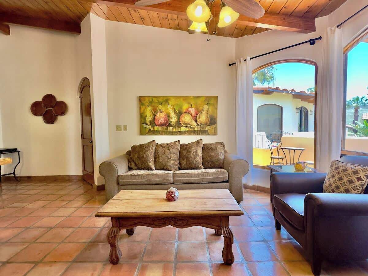 Un salon avec un canapé, une table basse et un tableau accroché au mur.