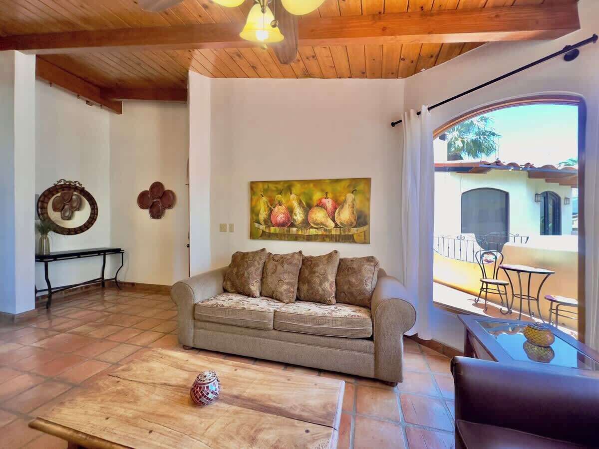 Una sala de estar con un sofá, una mesa de centro y un cuadro de fruta en la pared.