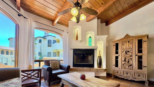 Un salón comedor amplio con chimenea, muebles de madera y vistas a la ciudad.