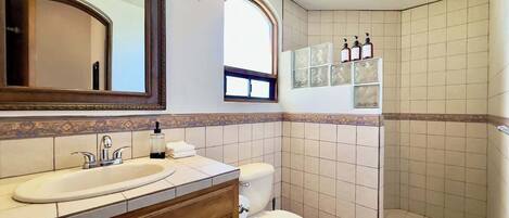 A bathroom with a sink, toilet, and shower.
