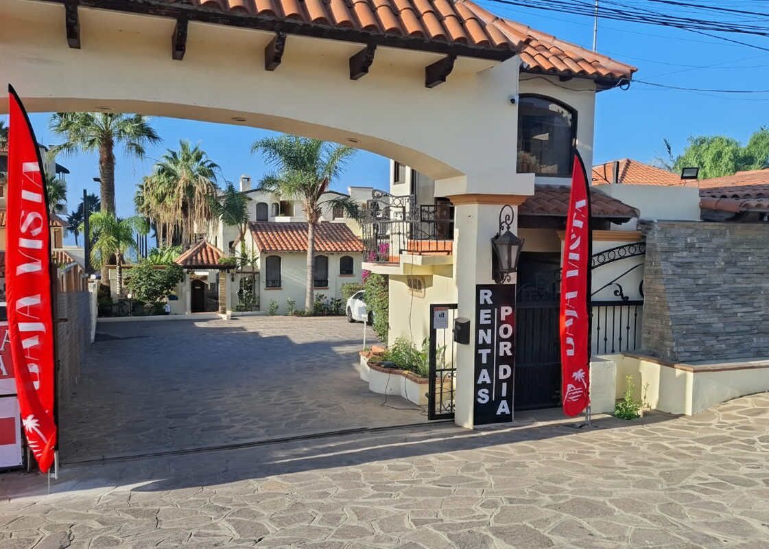 A gated entrance to a property with a sign reading "RENTAS PORDIA".