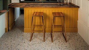 A kitchen with wooden bar stools, a central island, and pendant lighting. - The Tailor Shop. (Skibbereen)