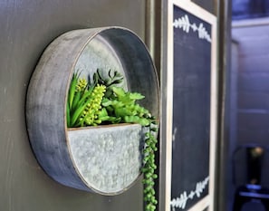Un pot à plantes fixé au mur, contenant des plantes vertes.