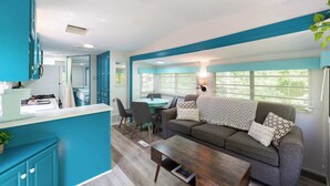 A modern living area with a sofa, coffee table, and dining table.