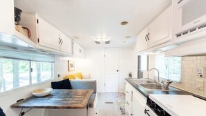 A compact kitchen with a dining area, a stove, and a sink.