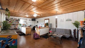 A cozy interior with a wooden ceiling, a kitchen area, a sofa, and a small table. - Blue Glamping RV w/ Nordic Spa Access near Grotto (Miller Lake)
