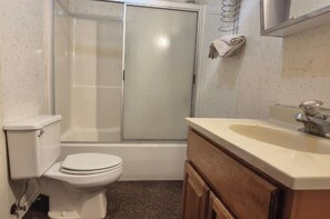 Une salle de bain comprenant des toilettes, une baignoire et un lavabo.
