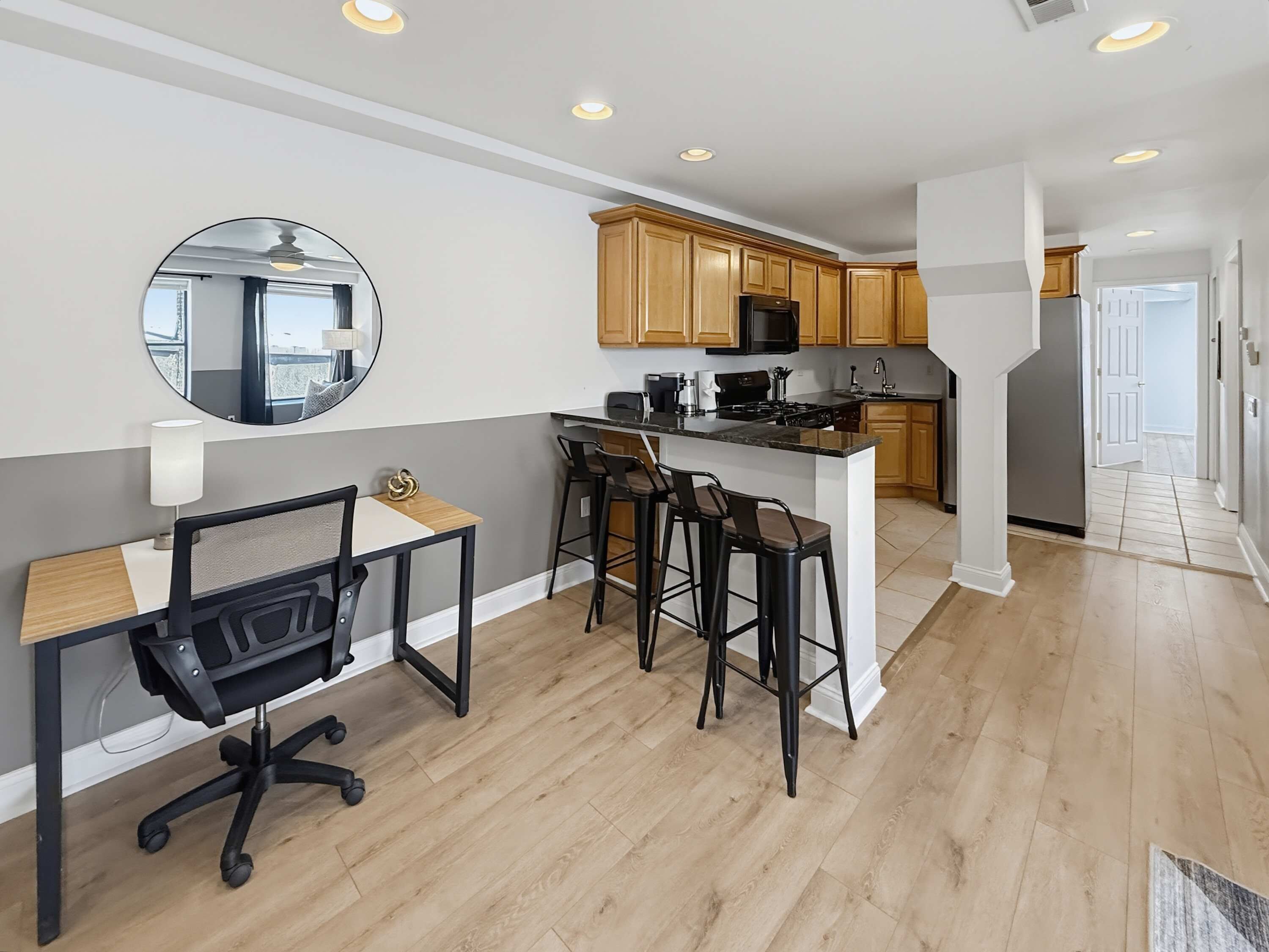 A modern kitchen with wooden cabinets, a central island, and a dining area with a table and chairs.