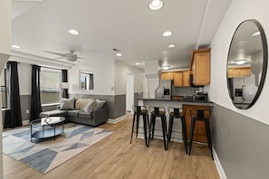 A modern apartment with a living area, kitchen, and dining space.