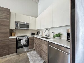 A modern kitchen with stainless steel appliances, a microwave, a toaster, and a sink.